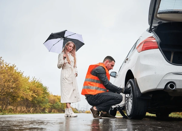 roadside-assistance-worker-replacing-flat roadside-assistance-worker-replacing-flat-tire